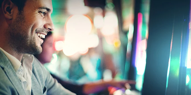 Smiling guest playing a slot machine in the casino