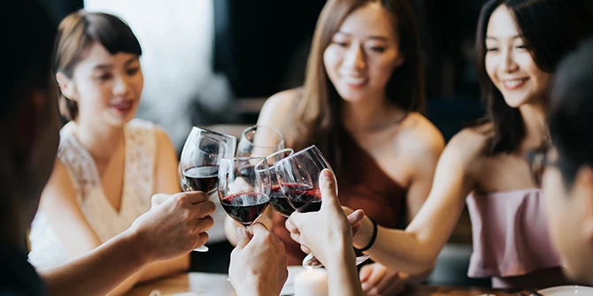 Friends raising wine glasses at dinner